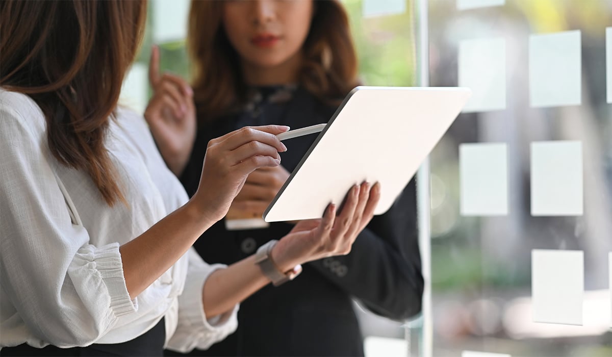Business women discussing digital tablet in office