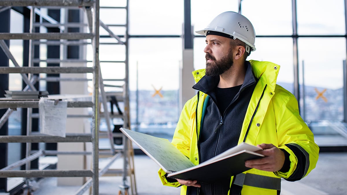 Man holding blueprints on construction site