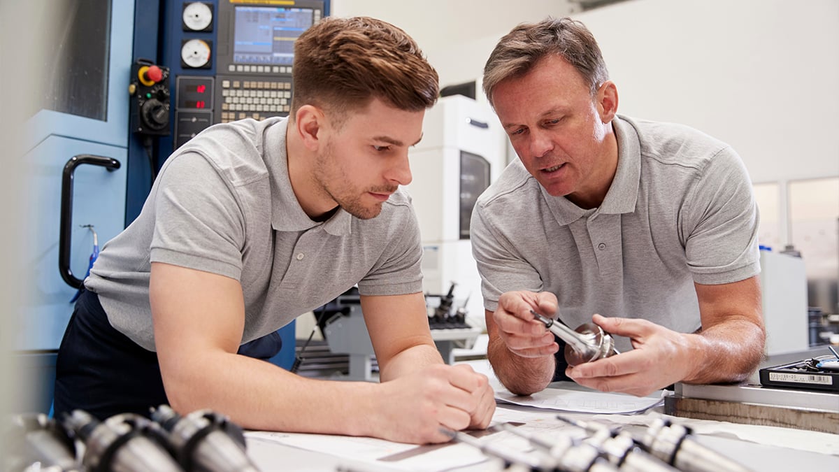 Engineers discussing machine parts