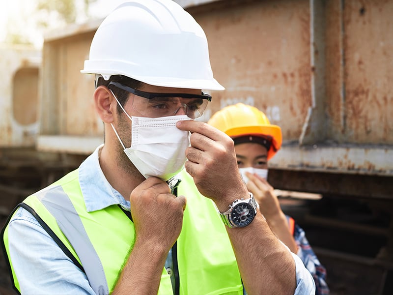Construction workers adjusting face masks