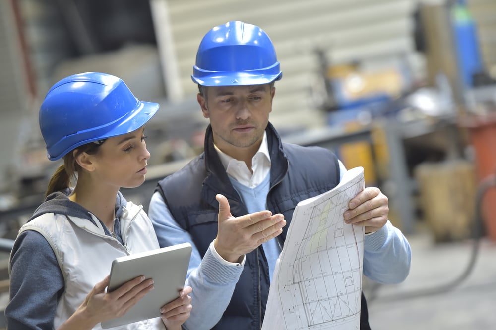 Engineers in mechanical factory reading instructions-1