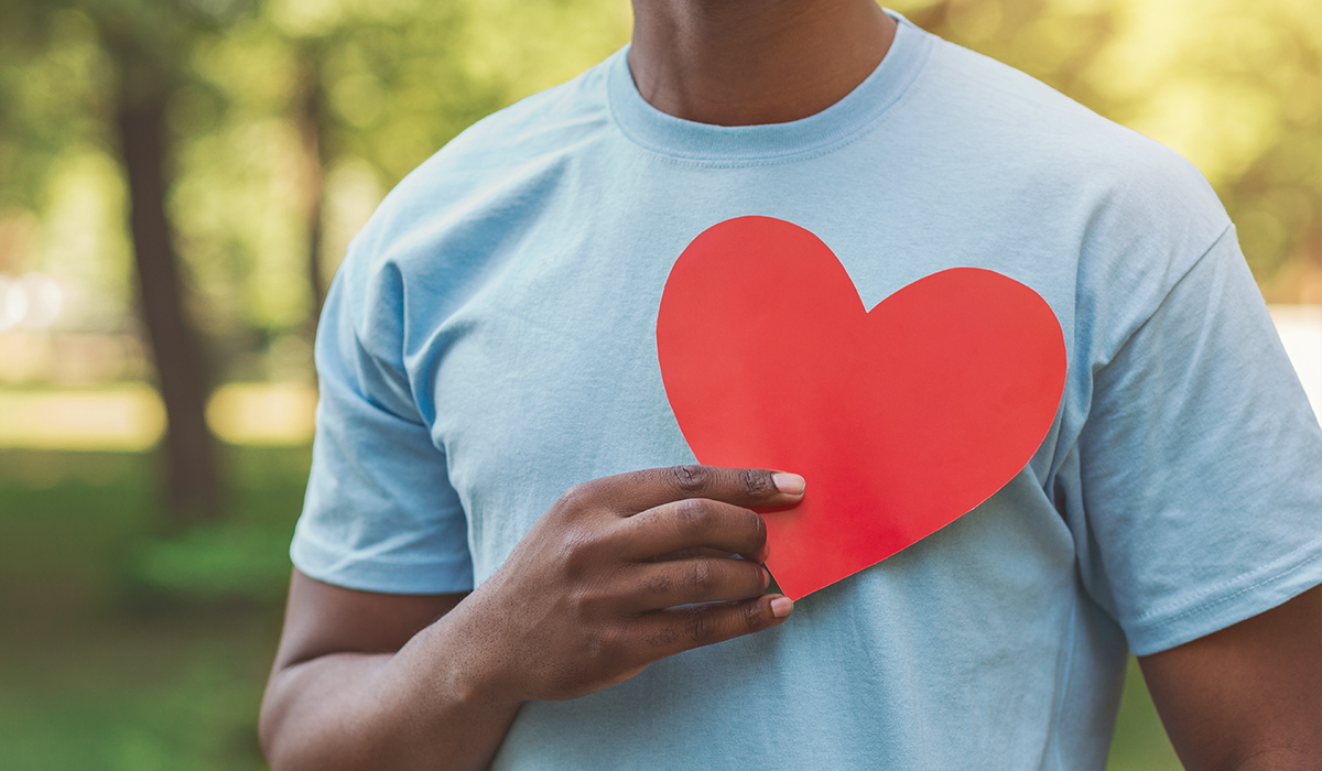 Man holding a red heart on his chest